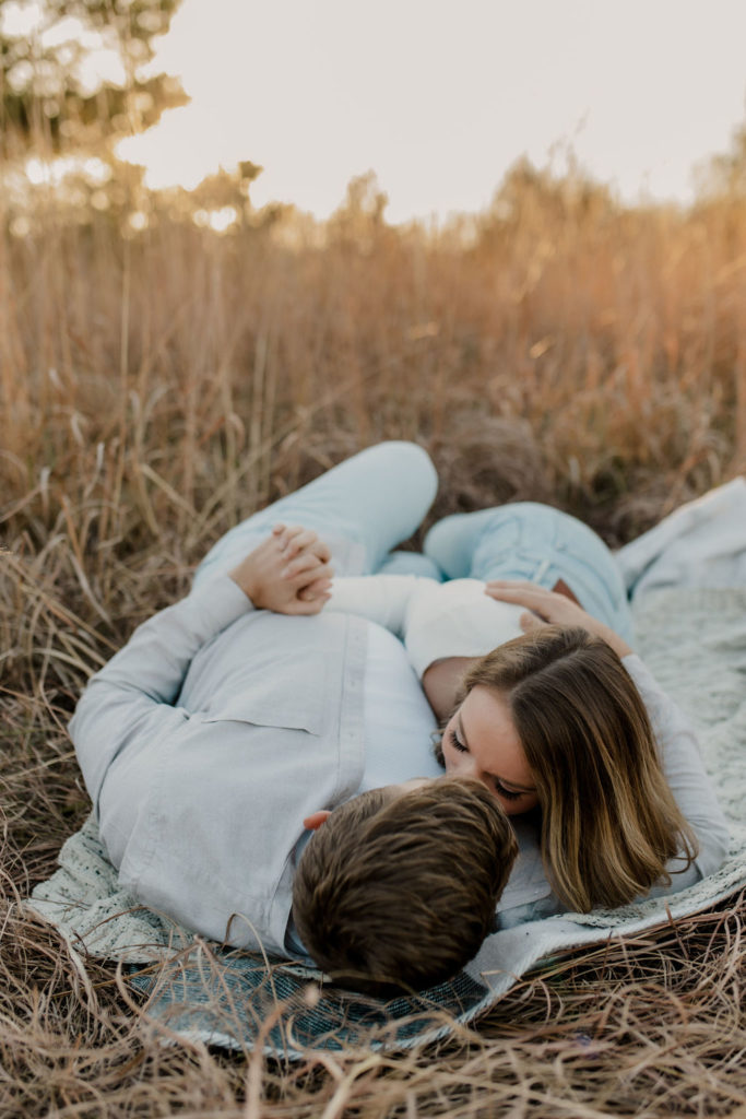 Fall Engagement Photo of Couple on Picnic Blanket Kissing
