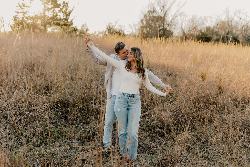 Couple holding hands spread apart in fall engagement photo