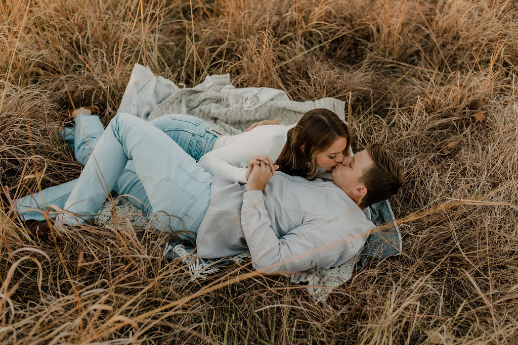 Couple kissing on blanket engagement photo