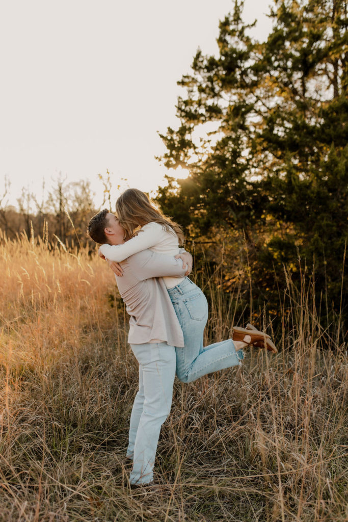 Man picks up woman in fall engagement photo session