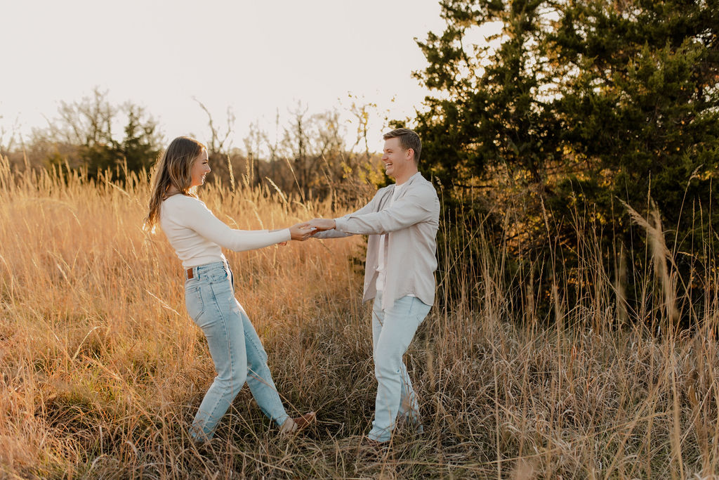Couple dances outside in fall engagement photos at Shawnee Mission Park, Kansas City